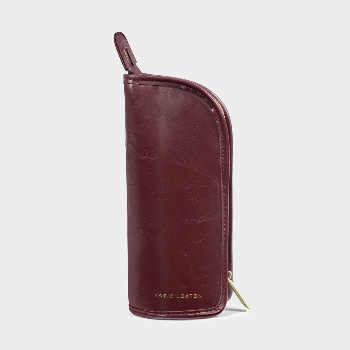 A burgundy leather zip-around wallet with a top loop and gold-tone hardware, including a small gold logo and zipper pull, shown on a light gray background.